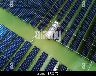 Luftbild des Sirajganj 68MW Solarparks mit Reihen von schwimmenden Solarpanelen, die auf grünem Wasser in Sirajganj, Rajshahi-Division, Bangladesch, installiert sind. Stockfoto