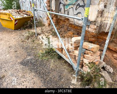 Renovierung eines alten roten Backsteinhauses mit Gerüst und Bauschuttcontainer Stockfoto