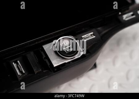 Ein Auto-Start-Stopp-Knopf und eine Innenverkleidung werden auf einem weißen Studiohintergrund fotografiert. Stockfoto