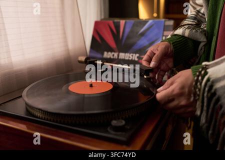 Männliche Hände platzieren eine Nadel auf einer Vinylplatte auf einem Plattenspieler Stockfoto
