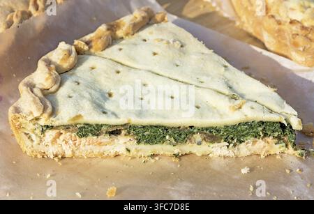 Scheibe hausgemachter Pastete mit Lachs und Spinat. Bild aufgenommen auf der Frühlingsmesse unter freiem Himmel an einem sonnigen Tag. Nahaufnahme Stockfoto