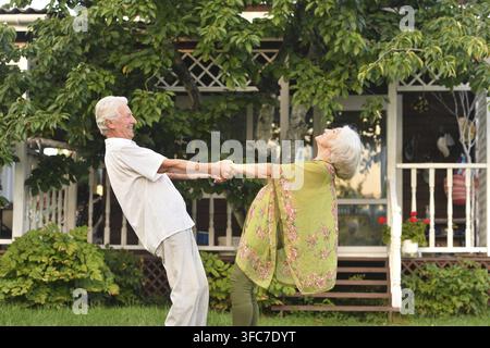 Niedliches älteres Paar tanzt in der Natur im Sommer Stockfoto