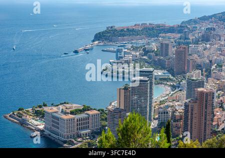Luftbild der Küste von Monaco mit dichter urbaner Bebauung, luxuriösen Wohntürmen, dem Hafen mit Yachten und dem Mittelmeer in Stockfoto