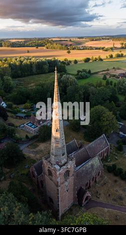 Drohnenansicht von St. Peter's Church in Worfield bei Sonnenuntergang mit historischem Dorf und der Landschaft von Shropshire, England, Vereinigtes Königreich Stockfoto