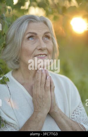 Nahaufnahme einer glücklichen älteren Frau, die draußen im Sommer steht Stockfoto