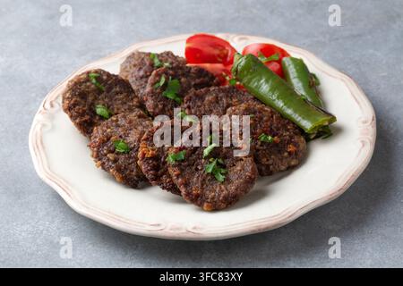 Traditionelle türkische gegrillte Fleischbällchen Kofte mit gerösteten Paprikaschoten und Tomaten Stockfoto