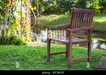 Alter Holzstuhl in einem tropischen Garten in der Nähe des Sees auf der Insel Borneo, Malaysia, Nahaufnahme Stockfoto
