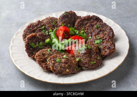 Traditionelle türkische gegrillte Fleischbällchen Kofte - Akcaabat kofte serviert mit frischen Tomaten und Paprika Stockfoto