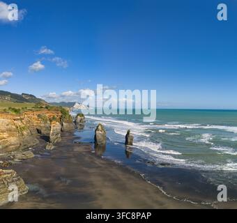 Luftbild der Three Sisters und des Elephant Rock auf dem schwarzen Sandstrand von Tongaporutu, Taranaki Region, Neuseeland. Stockfoto