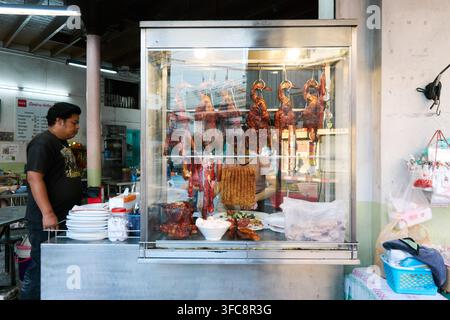 Restaurant an der Si Lom Road in Bangkok, Thailand, mit hinter einer Glasvitrine deutlich sichtbar ausgelegten gegartem Hühnern. Stockfoto