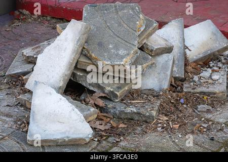 Ein Haufen zerbrochener Betonpflastersteine und Bauschutt liegt auf dem Boden während der Gehwegrenovierungsarbeiten. Stockfoto