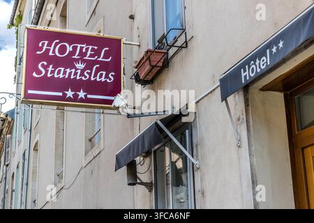Ein burgunderrotes Schild mit der Aufschrift „Hôtel Stanislas“ und zwei Sternen hängt an der Fassade eines Zwei-Sterne-Hotels am Boulevard du 26e Régiment d'Infanterie in Nancy, Grand Est, Frankreich. Der Name spielt auf den ehemaligen Herzog Stanislas Leszczyński an, dessen Erinnerung in ganz Nancy allgegenwärtig ist. Ein dunkles Vordach und eine Blumenkiste schmücken die Fenster darunter. Stockfoto