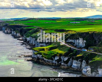 Luftbild von White Rocks Beach mit dramatischen Kalksteinklippen, einer sich windenden Küstenstraße, üppigen grünen Feldern und dem Atlantischen Ozean in Portrush, Nordirland Stockfoto