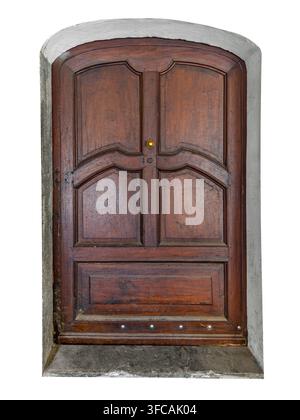Vintage braune Walnuss- oder Kastanienholz-Doppeltür mit kunstvollen Paneelen und Messinggriff, eingebettet in einen rustikalen weiß verputzten gewölbten Wanddurchgang. Ausschnitt-Clippi Stockfoto