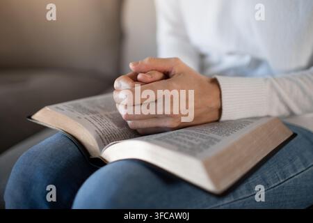 Frau hält eine Bibel und spricht ein Gebet. Stockfoto