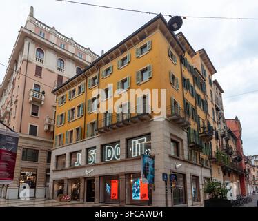 VERONA, ITALIEN - 23. OKTOBER 2024: Niedrige Blickwinkelansicht eines modernen Einzelhandelsgeschäfts im Erdgeschoss eines historischen gelben Gebäudeexterieurs Stockfoto