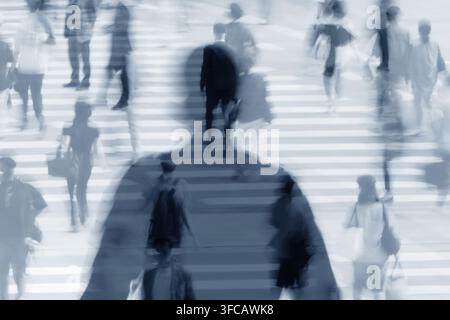 Silhouette einer Person in der Menge auf einem belebten Stadtüberweg. Stockfoto