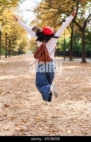 Frau springt im Park und genießt die herbstliche Freiheit Stockfoto