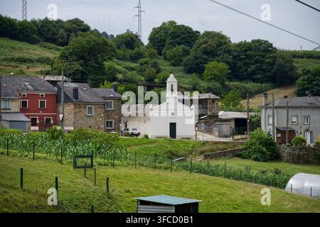 Kleine weiße Kapelle, umgeben von traditionellen Häusern und Ackerland in Grove. Stockfoto