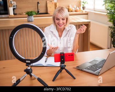 Professionelle Videobearbeitung zu Hause mit einem Smartphone, einem Ringlicht und einem Laptop. Stockfoto