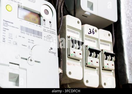 Stromzähler und Leistungsschalter in der Verteilerdose, smarter Stromzähler mit nummerierten Schaltern, Messung des Energieverbrauchs, Stromversorger Stockfoto