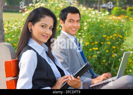 Unternehmer und Unternehmerin zu Fuß in einem park Stockfoto
