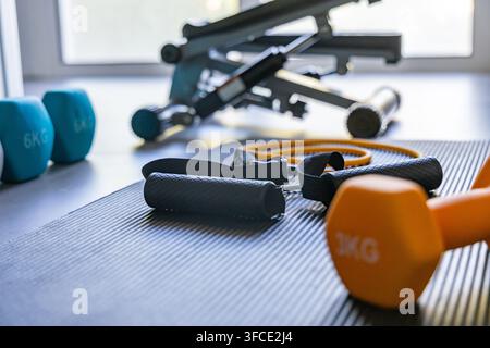 Eine Sammlung von Fitnessgeräten für ein Heimtraining, mit Gewichten und Trainingsmaschinen Stockfoto