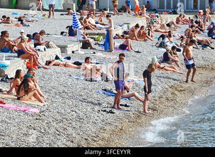 Ein lebhafter Kieselstrand in Dubrovnik im Sommer, an dem sich vielfältige Touristen an der Adriaküste sonnen und entspannen. Stockfoto