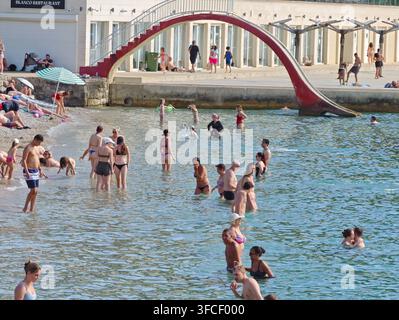 Ein lebhafter Kieselstrand in Dubrovnik im Sommer, an dem sich vielfältige Touristen an der Adriaküste sonnen und entspannen. Stockfoto