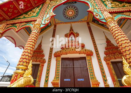 Dok kham tai, Phayao, Thailand - 27. August 2026: Wat Don Lek, Tempelingang mit goldenen Naga-Säulen und Holztüren Stockfoto