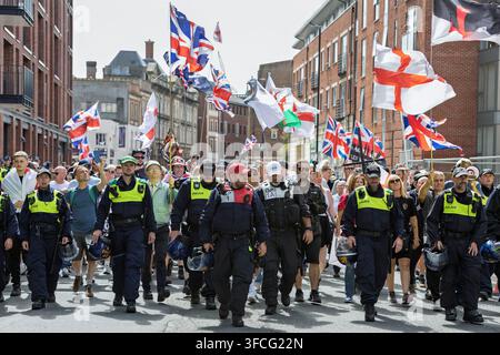 Bristol, UK. 8. August 2026. Polizei eskortiert „Stop the Boats“-Protestierende, während sie während einer Anti-Einwanderungs-Demonstration durch die Innenstadt marschieren. Stockfoto