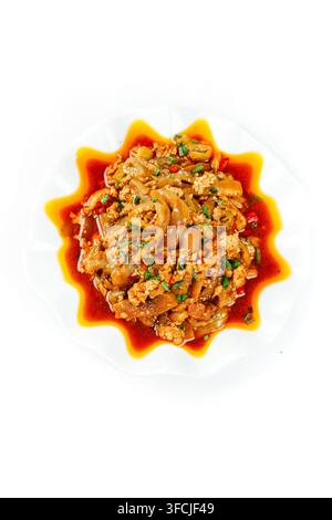 Scharfes Innerenien-Gericht mit Chili-Öl auf einem weißen Teller isoliert auf weißem Hintergrund. Stockfoto