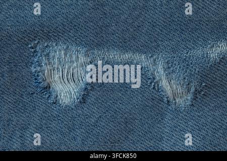 Zerrissene blaue Jeans mit ausgefransten Fäden und abgenutzten Texturmustern Stockfoto