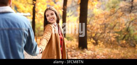 Herbstromantik und Beziehungsziele, glückliche junge Frau hält die Hand ihres Freundes in einem Herbstpark mit bunten Blättern Stockfoto