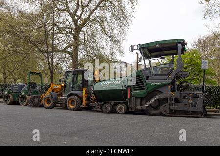 Schwere Straßenbaumaschinen, die auf der Straße geparkt sind. London, UK, 14. April 2024 Stockfoto