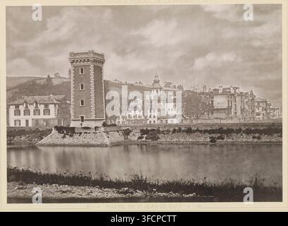 Phare de St Jean-de-Luz, Ansicht des Leuchtturms von Saint-Jean-de-Luz, Seite, photomechanischer Druck, Frankreich, Verlag: J. Rothschild, Paris, ca. 1873 - bis 1883, Papier, Kollotypie, Fotodruck, Höhe 233 mm x Breite 326 mm, Druck im Abschnitt hinten, Stadtansicht im Allgemeinen, 'Vedute', Leuchtturm, Leuchtschiff., Eine Flussszene in gedämpften Tönen, die einen hohen rechteckigen Turm mit dekorativen Steinecken zeigt, der auf einer erhöhten Steinplattform am Wasser steht, angrenzend an eine Reihe mehrstöckiger Gebäude mit unterschiedlichen Dachlinien und verschlossenen Fenstern, ein kleinerer Turm mit einem spitzen Dach und Stockfoto