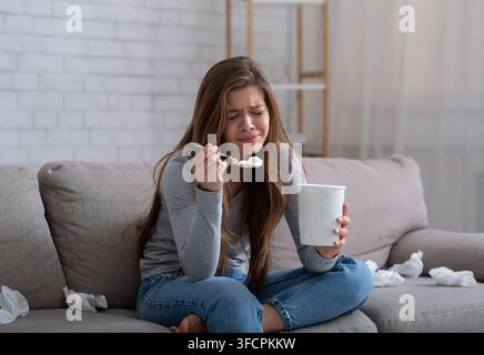 Traurige Millennial Dame weinend und Eis essen, während sie zuschaute Romantischer Film nach der Trennung Stockfoto