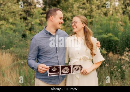 Fröhliches werdendes Paar teilt einen Moment mit dem Ultraschallbild Stockfoto