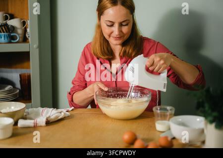 Frau verwendet einen Handrührer in der Küche, Heimbacken Stockfoto