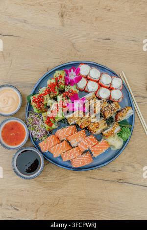 Ein großes gemischtes Sushi-Platte auf einem Holztisch mit Saucen Stockfoto
