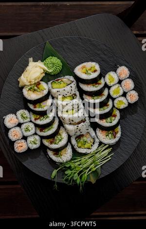 Eine Ansicht von oben auf ein großes Plateau mit verschiedenen Sushi-Rollen Stockfoto