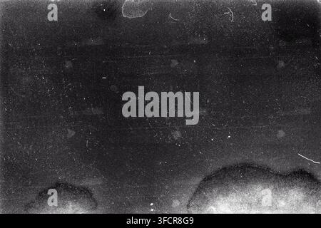 Ungebrannter, körniger Filmstreifenhintergrund mit starker Körnung, Staub und leichtem Leck. Der alte abgelaufene sowjetische Schimmelfilm-Scan. Schwarz-weiß. Stockfoto
