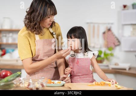 Gemeinsame Aktivitäten während der Feiertage. Mutter und Tochter essen zusammen, Mutter bereitet Frühstück für Tochter am Morgen vor, genießen, Woche Stockfoto