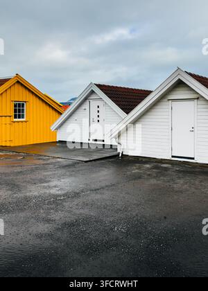 Ein malerischer Ausblick auf traditionelle skandinavische Holzarchitektur mit einer hellgelben Hütte und einem größeren hellgrünen Haus, das direkt am Stockfoto