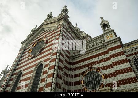 Ansicht der Kirche Unserer Lieben Frau von Lourdes mit ihrer markanten rot-weiß gestreiften neogotischen Fassade und kunstvollen Rosafenstern in Bogota, Bogota Stockfoto