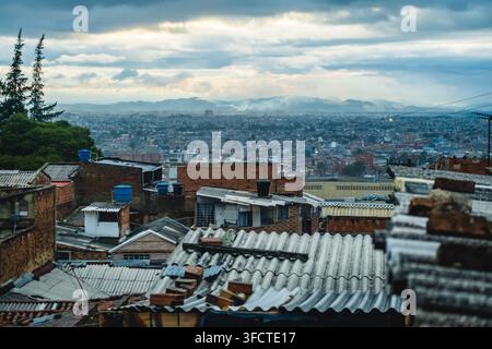 Blick auf dichte urbane Dächer und die weitläufige Stadtlandschaft von Bogota unter einem dramatischen bewölkten Himmel Bogota, Bogota, Kolumbien. Stockfoto