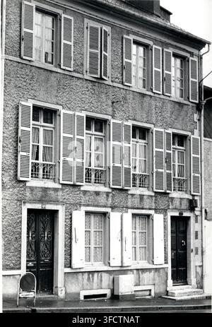 Ein dreistöckiges Steingebäude in Pau, von René Pérony im Jahr 1956, mit mehreren Fenstern und Fensterläden entlang einer Straße. Stockfoto