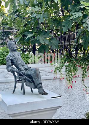 Jalta, Russland – 17. Juli 2022: Denkmal für Anton Tschechow sitzt unter einem Feigenbaum im Gedenkgarten Stockfoto