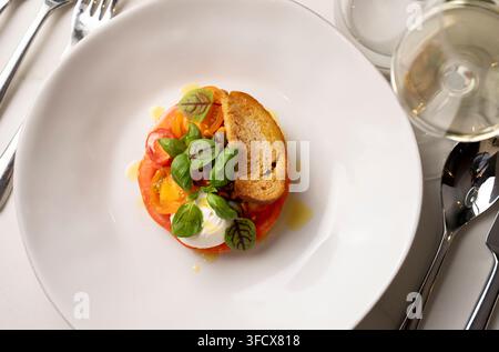 Tomaten-Basilikum- und Burrata-Salat - Essen, das in einem Restaurant serviert wird Stockfoto