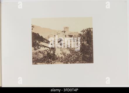 Ein steinernes Bauwerk, umgeben von Vegetation, mit einer Figur in der Nähe, in einem Foto von Félix-Jacques-Antoine Moulin, einem französischen Fotografen, aufgenommen in der Provinz Algier, Algerien, zwischen 1856 und 1857. Stockfoto